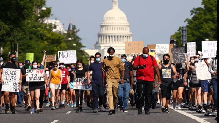 Diverse crowd of people in street protesting with signs in 2020 for Black Lives Matter at Capitol in Washington D.C.