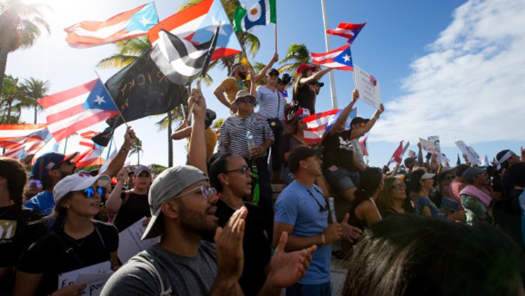 Crowd of people with flags protesting Telegramgate in Puerto Rico